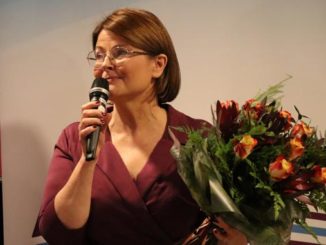 dyrektor biblioteki Magdalena Konczarek z bukietem kwiatów